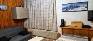 ein Wohnzimmer mit einem Sofa und einem TV in der Unterkunft Appartement d'une chambre avec vue sur la ville balcon et wifi a Chamrousse in Chamrousse