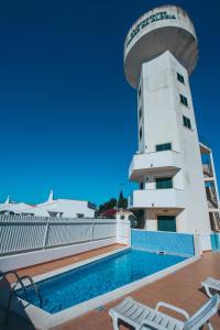 een zwembad op het dak van een gebouw met een toren bij Torre da Aldeia by Umbral in Albufeira