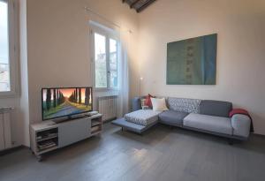 salon z kanapą i telewizorem z płaskim ekranem w obiekcie Apartments Florence Pepi attic we Florencji