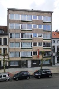 two cars parked in a parking lot in front of a building at Budget Flats Antwerp in Antwerp