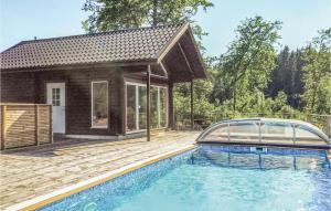 a house in the woods with a swimming pool at Amazing Home In Dalsjöfors With Sauna in Dalsjöfors