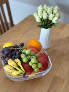 a bowl of fruit on a table with a vase of flowers at Ferienwohnung "Am Walde" in Lubmin