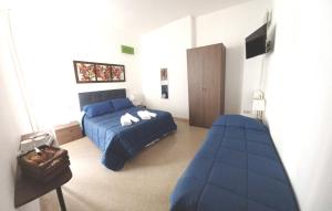 sypialnia z niebieskim łóżkiem i kanapą w obiekcie La Dimora dei Professori DiffusHotel w mieście Lecce