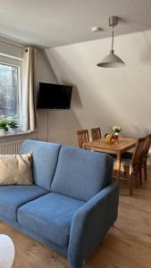 ein blaues Sofa im Wohnzimmer mit einem Tisch in der Unterkunft Ferienwohnung "Am Walde" in Lubmin