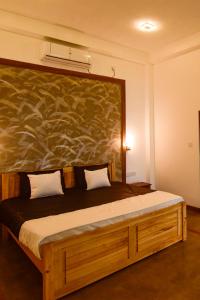 a bedroom with a bed with a large painting on the wall at Hiru Lagoon Negombo in Negombo
