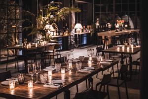 - un restaurant avec des tables et des chaises en bois et des verres à vin dans l'établissement Locanda Cossetti Ranch Winery, à Incisa Scapaccino