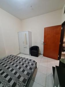 a bedroom with a black and white bed and a door at Almond Tower, Garden City in Ajman 