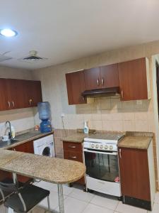 a kitchen with wooden cabinets and a stove top oven at Almond Tower, Garden City in Ajman 
