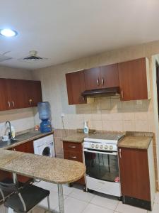 cocina con armarios de madera y horno con fogones en Almond Tower, Garden City, en Ajman