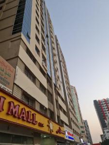 ein großes Gebäude mit einem Einkaufsschild davor in der Unterkunft Almond Tower, Garden City in Ajman 