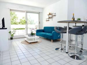 salon z niebieską kanapą i stołem w obiekcie Appartement terrasse panoramique Hôpitaux et Facultés w Montpellier