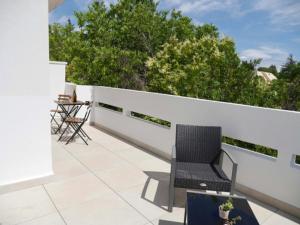 patio z dwoma krzesłami na białym płocie w obiekcie Appartement terrasse panoramique Hôpitaux et Facultés w Montpellier