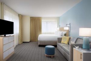 um quarto de hotel com uma cama e um sofá em Sonesta ES Suites New Orleans Downtown em Nova Orleans