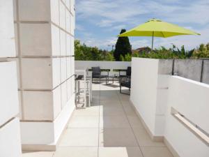 patio z żółtym parasolem, stołami i krzesłami w obiekcie Appartement terrasse panoramique Hôpitaux et Facultés w Montpellier