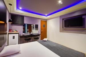 サンパウロにあるSoft Motel - USPのベッドルーム1室(ベッド1台付)、キッチン(テレビ付)