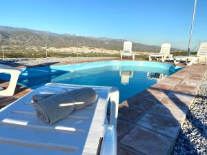 una toalla sentada en un banco junto a una piscina en Casa El Barranco By Solymar Holiday, en Vélez-Málaga