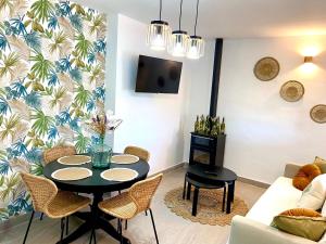 uma sala de estar com mesa e cadeiras em Casa El Barranco By Solymar Holiday em Vélez-Málaga