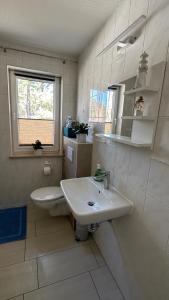 a white bathroom with a sink and a toilet at Ferienwohnung "Am Walde" in Lubmin