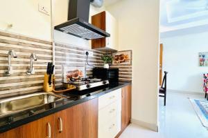a kitchen with a sink and a stove at BluO 1BHK Suite Gachibowli - Terrace Garden, Lift in Hyderabad