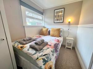 a bedroom with a bed with pillows on it at Shrimpy- A cute family friendly chalet in Cromer in Cromer
