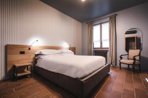 een slaapkamer met een groot bed en een stoel bij Locanda Cossetti Ranch Winery in Incisa Scapaccino
