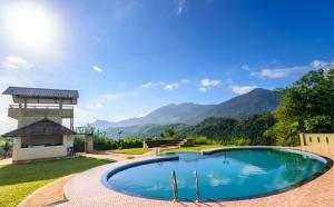 a swimming pool in a yard with a gazebo at Wayanad Village Resort in Koroth