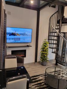 salon z kominkiem i telewizorem z płaskim ekranem w obiekcie moraleja suite 3 w mieście Alcobendas