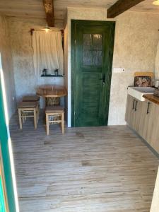 eine grüne Tür in einem Zimmer mit einem Tisch und einem Waschbecken in der Unterkunft Holiday Home Anka in Gospić