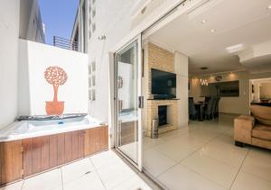 baño grande con bañera y chimenea en Urban Style House with Jacuzzi & Garage, en Ciudad del Cabo