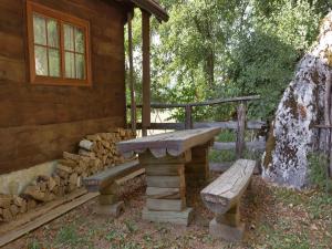 un banc en pierre assis à l'extérieur d'une cabane en rondins dans l'établissement Holiday Home Jela, à Gospić