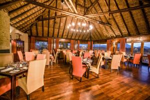 a restaurant with tables and chairs in a room at Pestana Kruger Lodge in Malelane