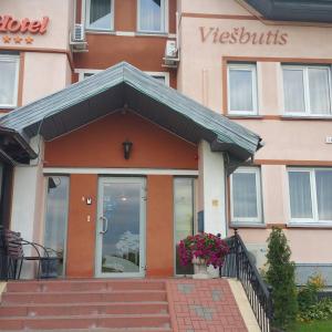 una puerta de entrada de un edificio con una maceta de flores en Hotel Pajurio vieskelis en Klaipėda