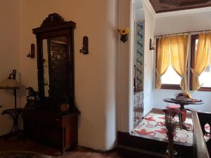 sala de estar con reloj de abuelo y ventana en Хотел Тома, en Sliven