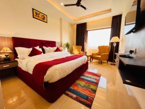 Habitación de hotel con cama grande y escritorio. en Hotel Gange, Haridwar, en Haridwar