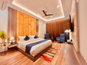 a bedroom with a king sized bed and a television at Hotel Gange, Haridwar in Haridwār