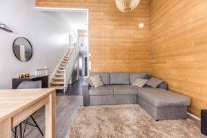 ein Wohnzimmer mit einem Sofa und Holzwänden in der Unterkunft SkyVillas B29 in Kalajoki
