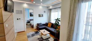 バニャ・ルカにあるExtra Apartmanのソファとテレビのあるリビングルーム