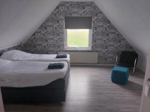 1 dormitorio con 1 cama, 1 silla y 1 ventana en Vakantiehuisje 't Wiede, en Blokzijl