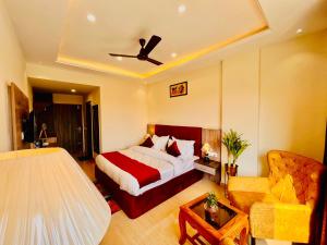 Habitación de hotel con cama y sofá en Gange Blossam, Haridwar en Haridwār