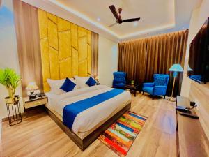 1 dormitorio con 1 cama extragrande y sillas azules en Gange Blossam, Haridwar en Haridwār