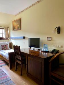 Zimmer mit einem Schreibtisch, einem TV und einem Bett in der Unterkunft Gościniec Oycowizna in Lesznowola