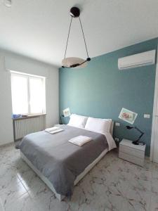 ein Schlafzimmer mit einem großen Bett mit blauer Wand in der Unterkunft Casa Nerea - Camere Rooms in Verona