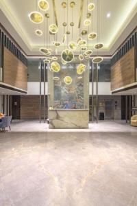 a large lobby with a large chandelier in a building at The Fern Residency Calangute-Baga, Goa in Calangute
