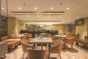 a restaurant with tables and chairs and a couch at The Fern Residency Calangute-Baga, Goa in Calangute