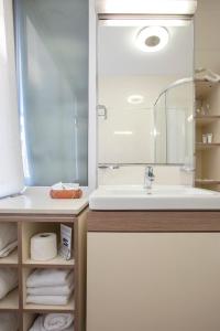 a bathroom with a sink and a mirror and towels at Hotel Srbija Garden-FREE PARKING in Belgrade