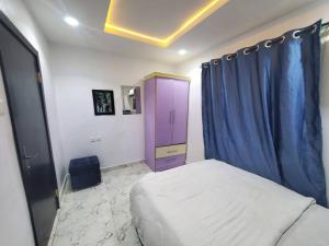 a bedroom with a bed and a blue curtain at Spacious 2-bed Apt With 24hrs Power+ Unlimited Wi-Fi in Lagos