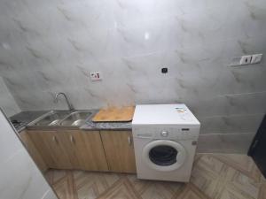 a kitchen with a washing machine and a sink at Spacious 2-bed Apt With 24hrs Power+ Unlimited Wi-Fi in Lagos