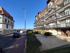 a car parked in a parking lot next to a building at Studio - Phalènes proche CID in Deauville