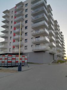 un grand immeuble en face d'un parking dans l'établissement Apartament Mielczarskiego, à Elbląg