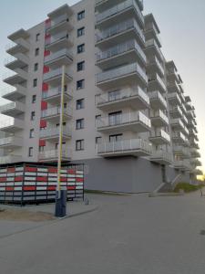 a tall apartment building in front of a parking lot at Apartament Mielczarskiego in Elblag